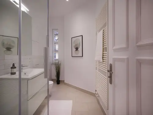 Weißes Bad mit Glasdusche und Design-Heizkörper nach Modernisierung